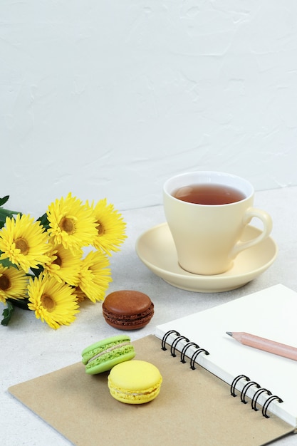 Tazza di tè, amaretto e note sul tavolo di cemento