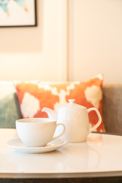 tazza di tè bianco con teiera sul tavolo