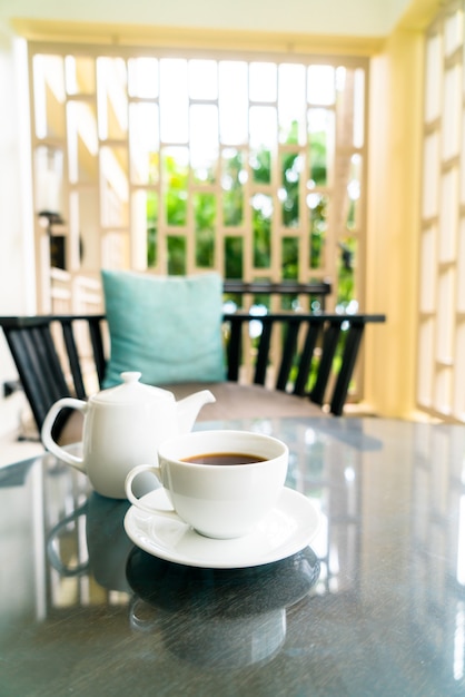 tazza di tè bianco con teiera sul tavolo