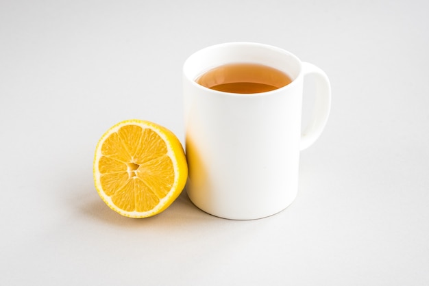 Tazza di tè caldo con limone e pillole su una superficie di legno. Malattia catarrale. Stagione influenzale.