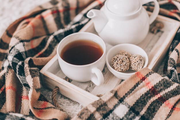 Tazza di tè caldo e teiera su un vassoio da portata