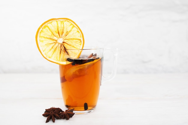 Tazza di tè con arancia e cannella su bianco