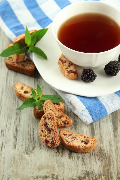 Tazza di tè con biscotti e mora sul primo piano della tavola