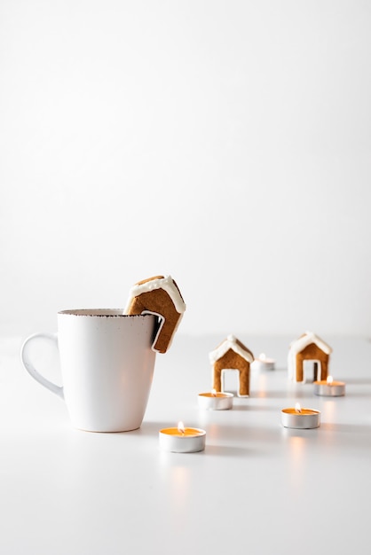 Tazza di tè con casa di marzapane e candele