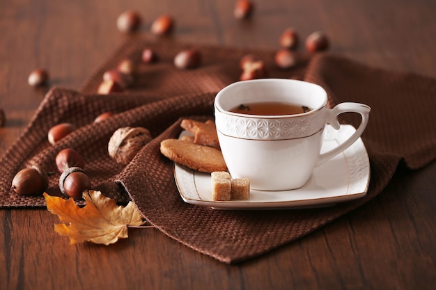 Tazza di tè con decorazioni autunnali sul tavolo di legno