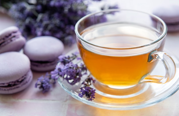 Tazza di tè con dessert amaretto al gusto di lavanda su sfondo di piastrelle rosa