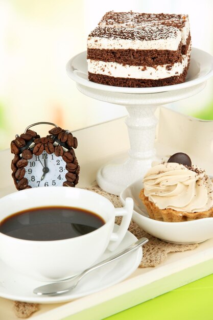 Tazza di tè con dolci sul vassoio di legno sul tavolo in camera