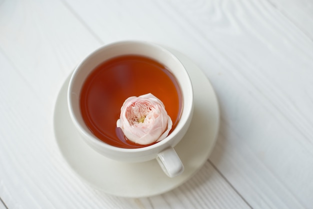 Tazza di tè con fiori freschi su uno sfondo bianco. Vista dall'alto Spazio per copia.