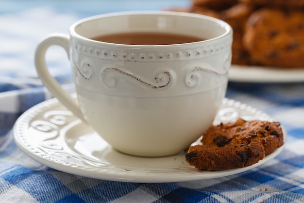 Tazza di tè con i biscotti di farina d'avena su una parete di legno