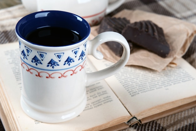 Tazza di tè con il libro sul primo piano del tavolo