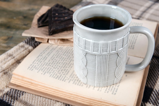 Tazza di tè con il libro sul primo piano del tavolo