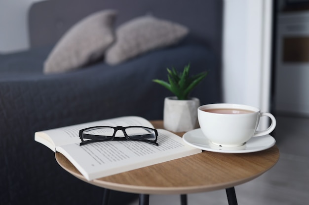 Tazza di tè con libri sul tavolo in camera