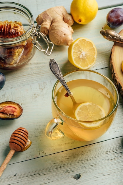 Tazza di tè con limone, miele e zenzero sulla superficie in legno