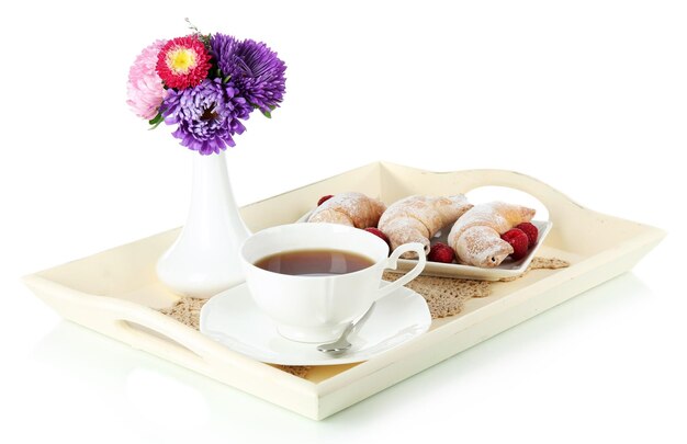 Tazza di tè con torte su vassoio in legno isolato su bianco