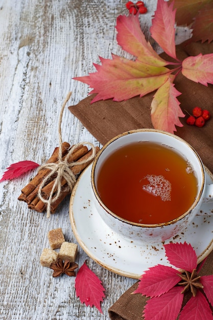 Tazza di tè di autunno su fondo in legno chiaro