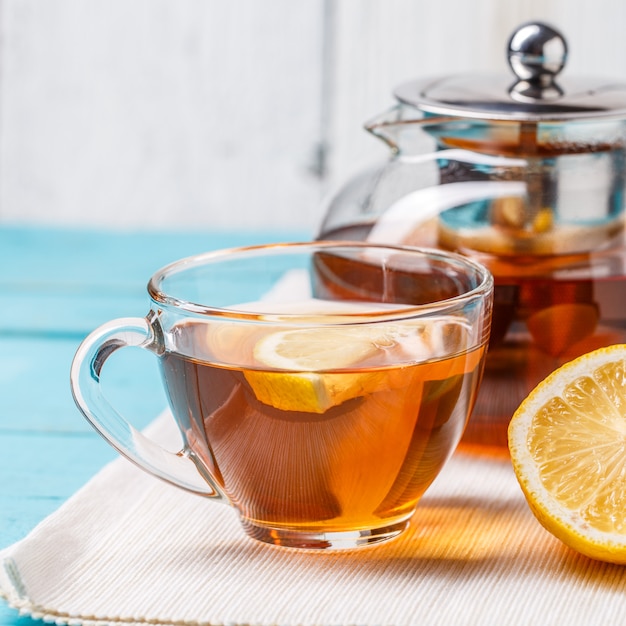 Tazza di tè di vetro con teiera di vetro e limone.