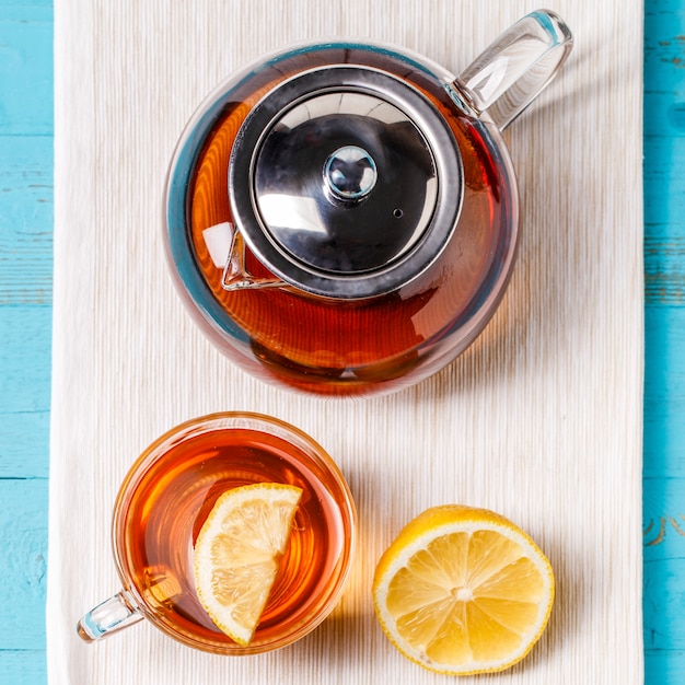 Tazza di tè di vetro con teiera di vetro e limone.