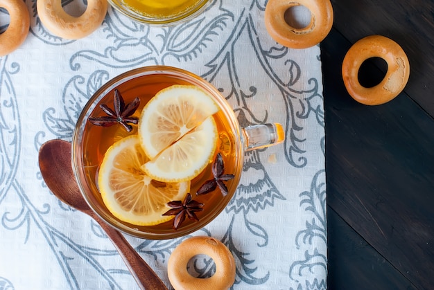 Tazza di tè e bagel su un tavolo di legno.