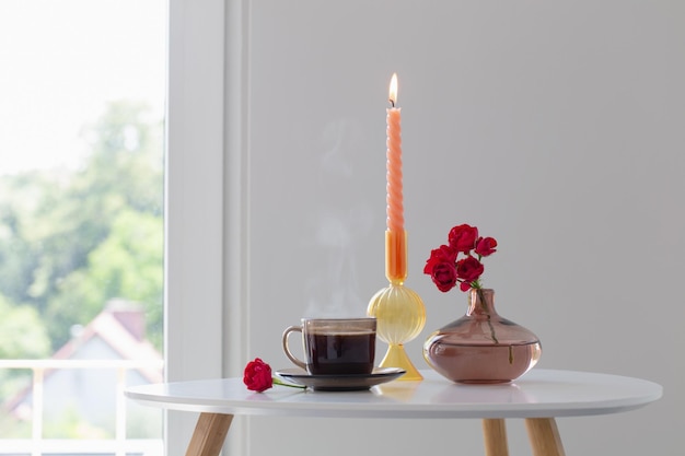 Tazza di tè e bouquet di rose in interni bianchi