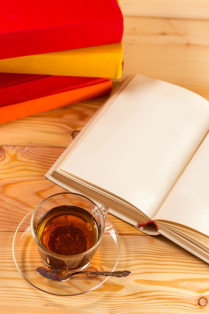 Tazza di tè e libri su sfondo di legno