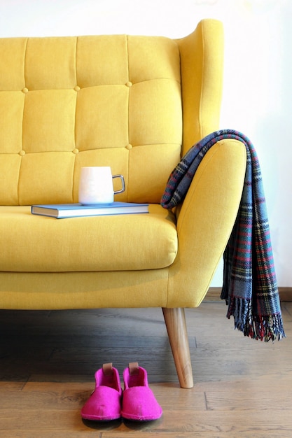 Tazza di tè e libro blu su un pullman giallo still life dettagli nell'interno domestico del soggiorno