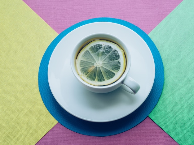 Tazza di tè e limone Sfondo di carta colorata.