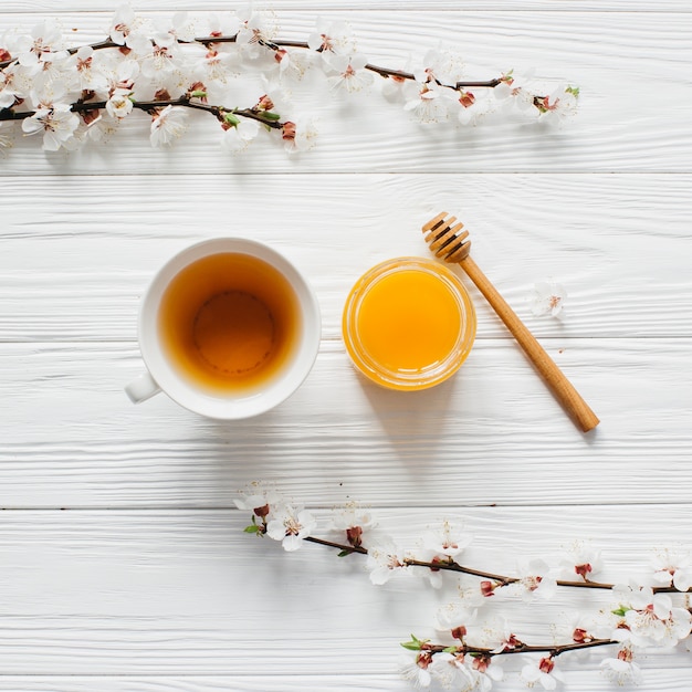 Tazza di tè e miele su fondo in legno