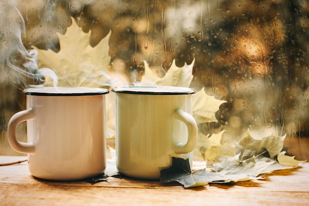 Tazza di tè in una foglia di giorno di umore autunnale finestra piovosa