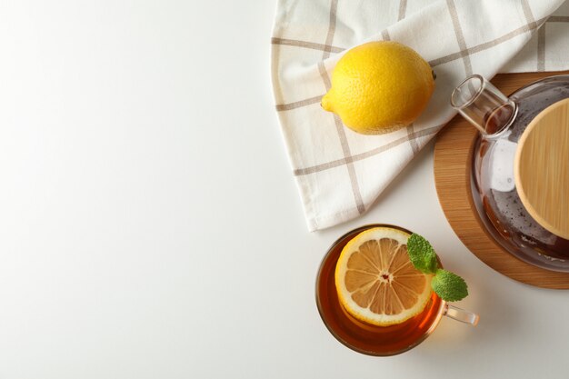 Tazza di tè, menta, limone, teiera e asciugamano su bianco, copia spazio