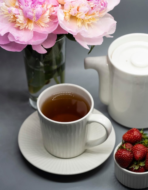 Tazza di tè, peonia e frutti di bosco