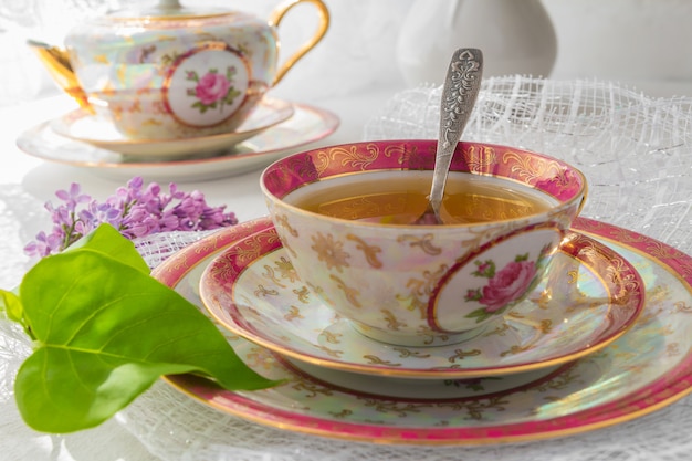 Tazza di tè su un tavolo luminoso vicino a una finestra al mattino e mazzi di fiori con uno spazio di copia