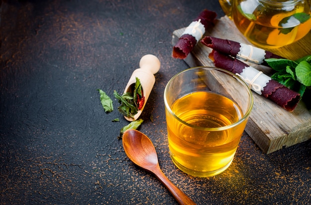 Tazza di tè, tè in un cucchiaio e frutta secca