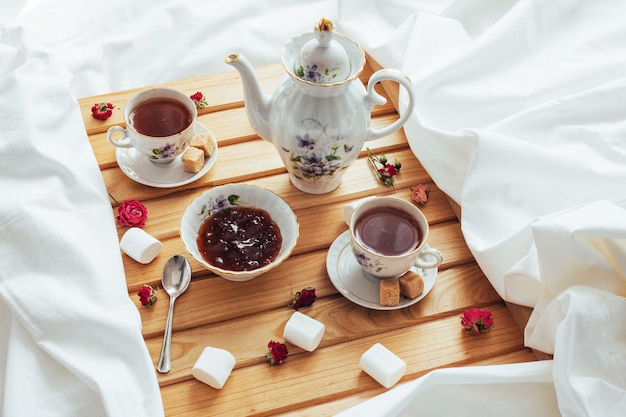 Tazza di tè, teiera, cucchiaio e zucchero isolati