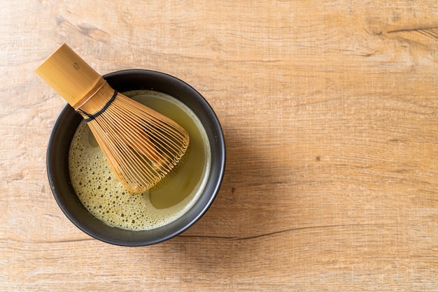 tazza di tè verde matcha calda con polvere di tè verde e frusta