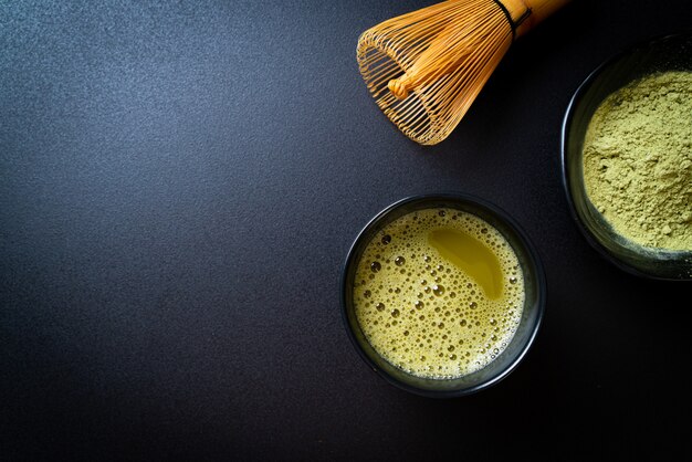 tazza di tè verde matcha calda con polvere di tè verde e frusta