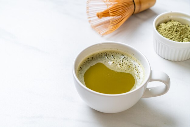 tazza di tè verde matcha calda con polvere di tè verde e frusta