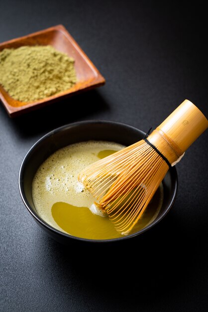 tazza di tè verde matcha calda con polvere di tè verde e frusta