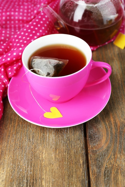 Tazza di teiera e bustine di tè sul primo piano della tavola di legno