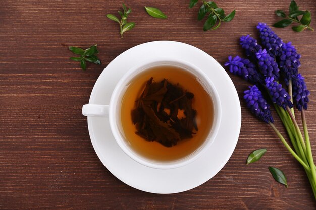 Tazza di tisana con fiori sulla vista dall'alto del tavolo in legno