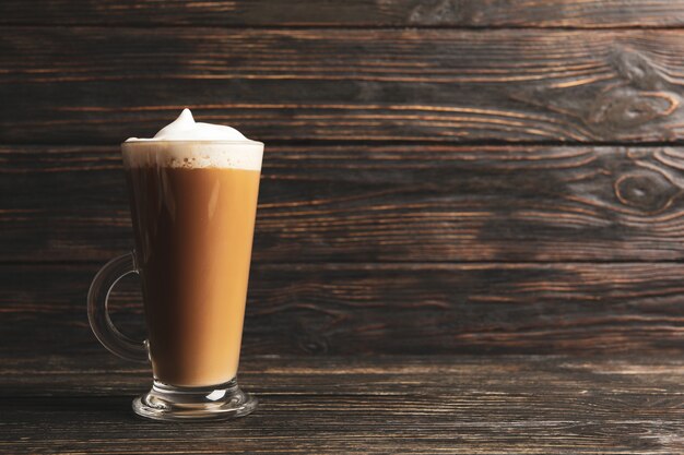 Tazza di vetro di latte su fondo in legno