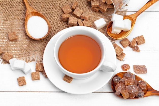 Tazza di vetro di tè caldo con zucchero sul tavolo