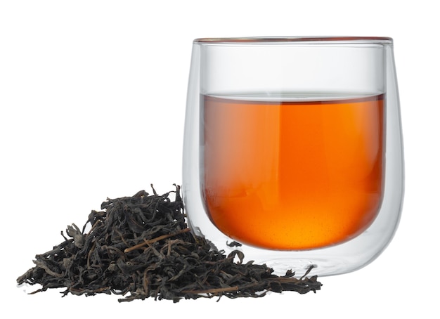 Tazza di vetro di tè con foglie di tè secche isolate