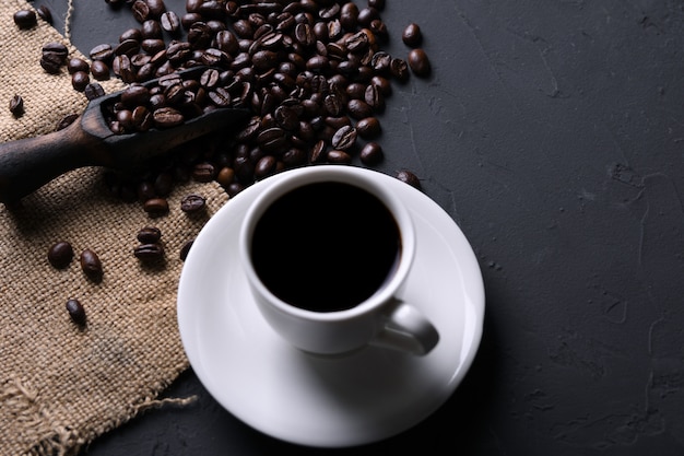 Tazza e fagioli di caffè sul vecchio beton grigio della cucina, tavola della roccia. con copyspace