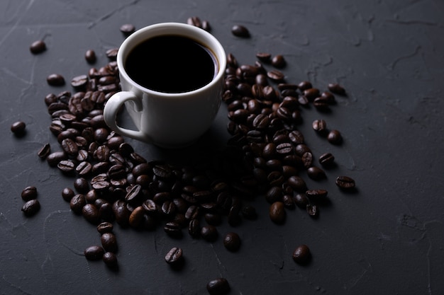 Tazza e fagioli di caffè sul vecchio beton grigio della cucina, tavola della roccia. con copyspace