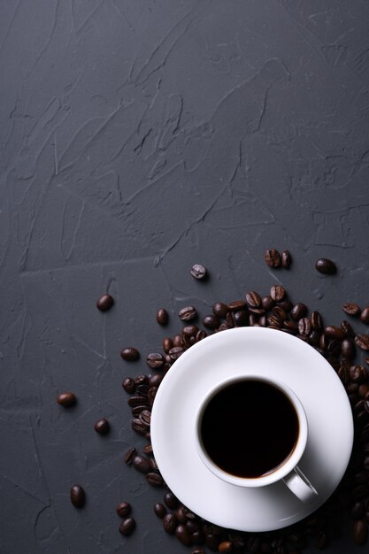 Tazza e fagioli di caffè sul vecchio beton grigio della cucina, tavola della roccia. Vista dall'alto con copyspace per il testo