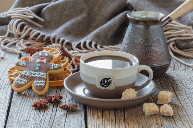 Tazza e spezie di caffè sulla tavola di legno