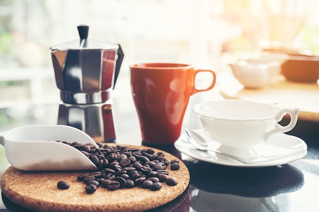 Tazza e tazza di caffettiera argento sul desktop