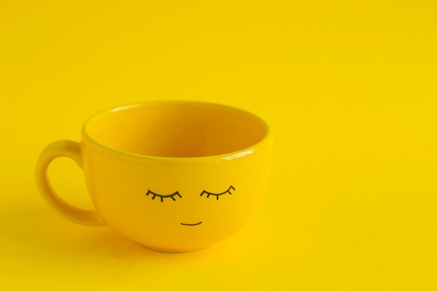 Tazza gialla con viso carino sorriso su giallo