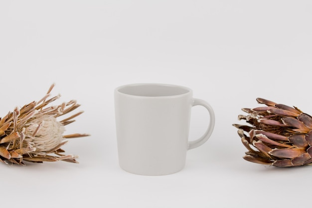 Tazza grigia con fiori secchi sul tavolo