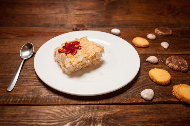 Tazza gustosa torta di pasticceria di cappuccino sulla tavola di legno